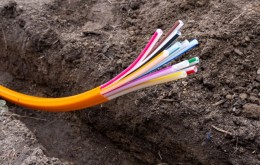 orange plastic cables for optical fiber, laid in an earth trench